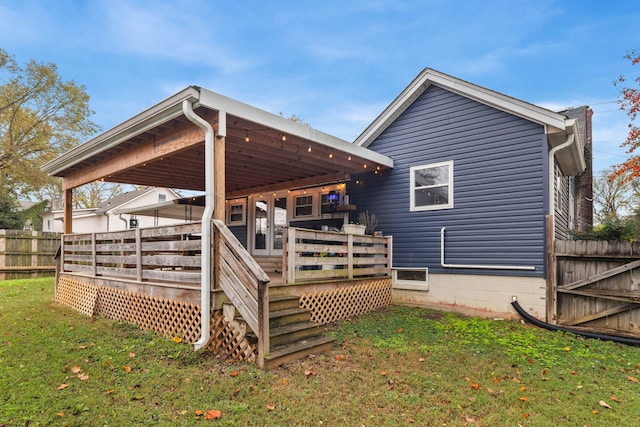 rear view of property featuring a wooden deck and a yard