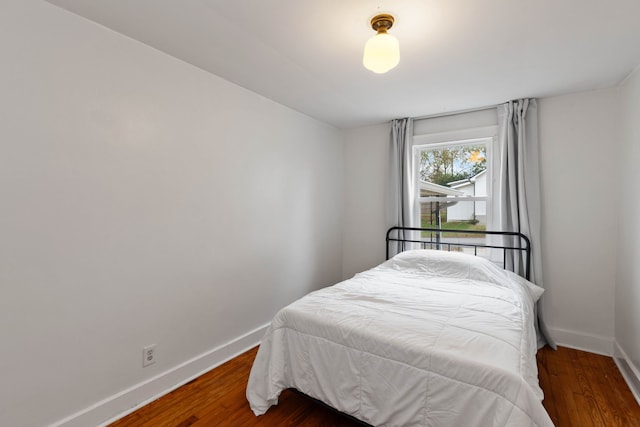 bedroom with dark hardwood / wood-style floors