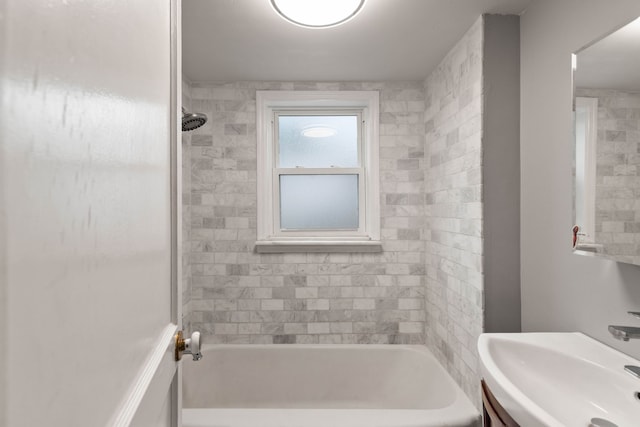 bathroom with tiled shower / bath combo and sink