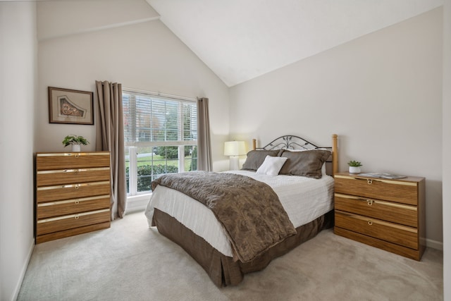 carpeted bedroom with high vaulted ceiling