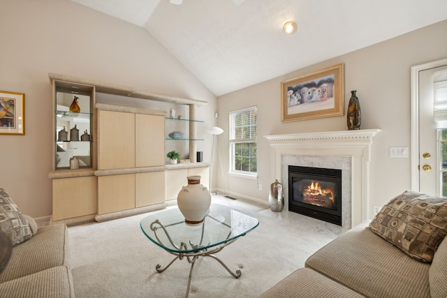 living room featuring a fireplace, light carpet, and lofted ceiling