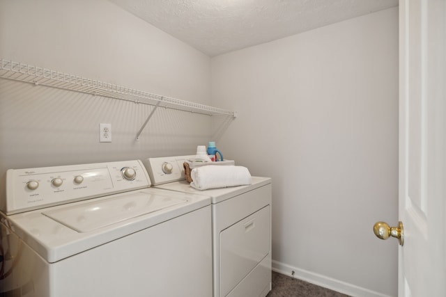 clothes washing area featuring dark carpet, separate washer and dryer, and a textured ceiling