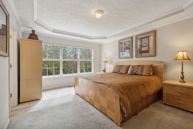 carpeted bedroom featuring ornamental molding, a textured ceiling, and a tray ceiling