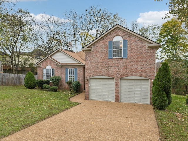 view of property featuring a garage and a front lawn