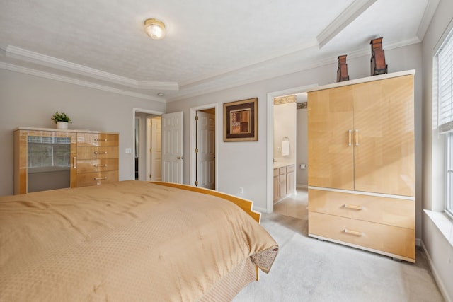 carpeted bedroom with a raised ceiling, ensuite bathroom, and crown molding