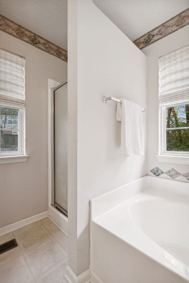 bathroom featuring tile patterned floors and shower with separate bathtub