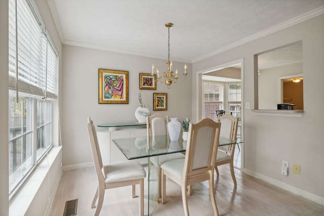 dining space featuring ornamental molding, light hardwood / wood-style floors, plenty of natural light, and a notable chandelier