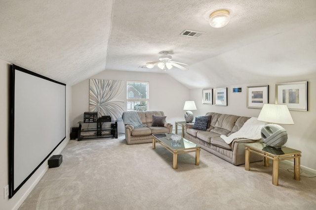 carpeted living room with a textured ceiling, vaulted ceiling, and ceiling fan