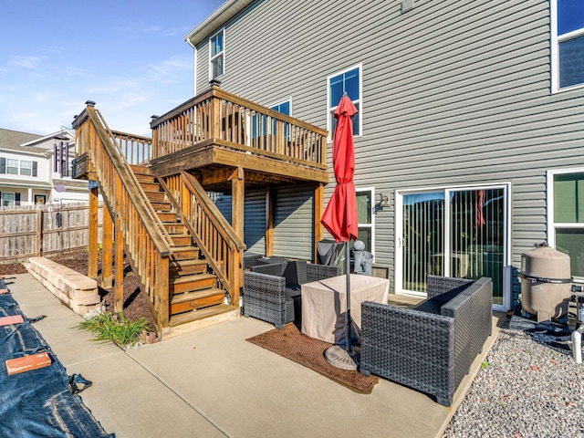 rear view of property featuring a wooden deck and a patio area