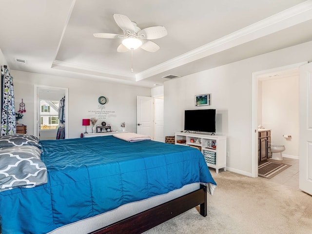 carpeted bedroom with ensuite bathroom, ceiling fan, a raised ceiling, and crown molding