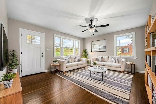 living room with dark wood-type flooring and ceiling fan