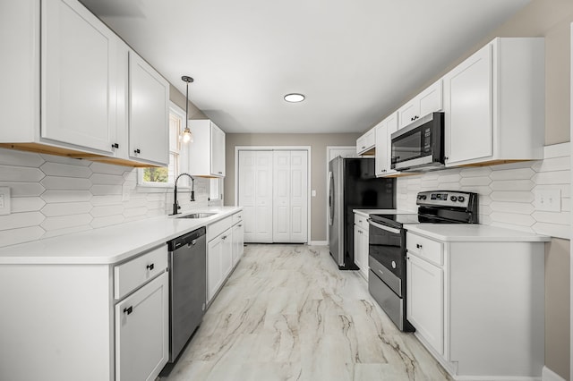 kitchen with hanging light fixtures, white cabinets, sink, and stainless steel appliances