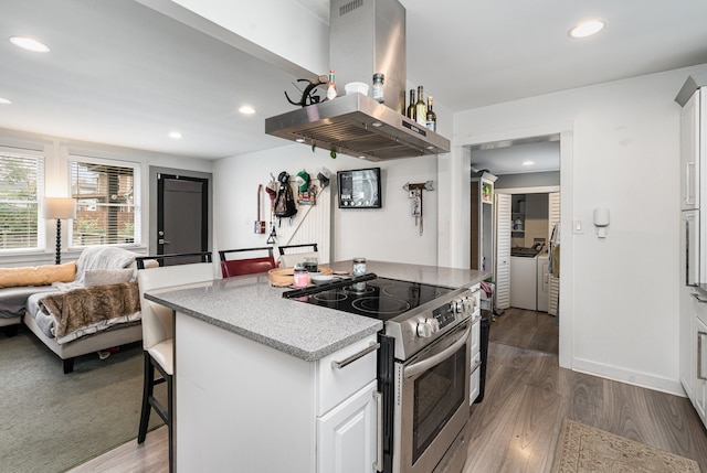 kitchen with island range hood, white cabinets, dark wood-type flooring, and stainless steel electric range