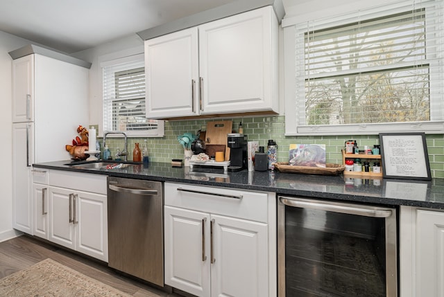 kitchen featuring dishwasher, white cabinets, beverage cooler, and sink