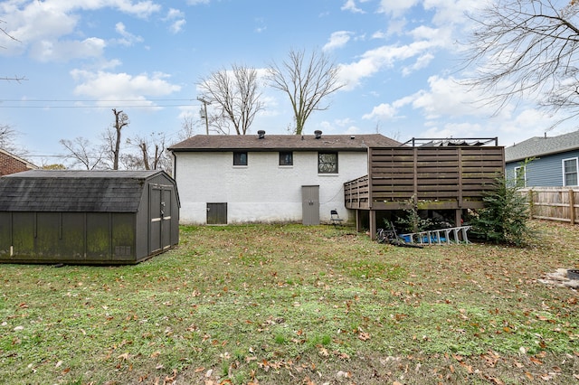 back of house featuring a yard, a deck, and a shed