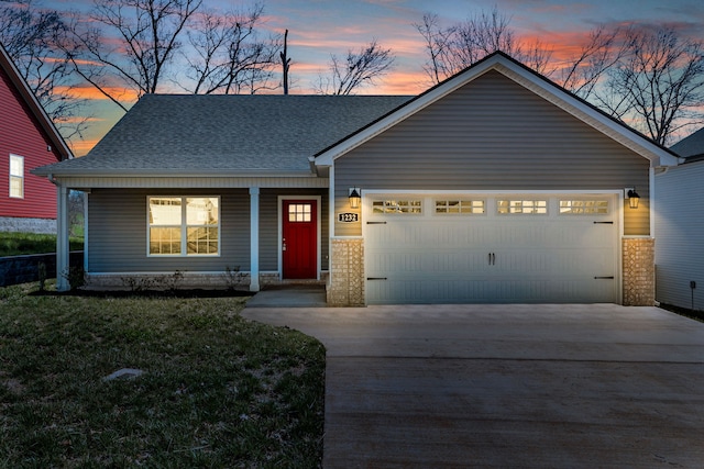 view of front of home with a garage, a lawn, and covered porch