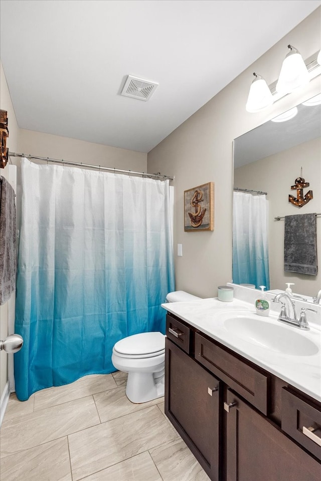 bathroom featuring a shower with shower curtain, vanity, and toilet