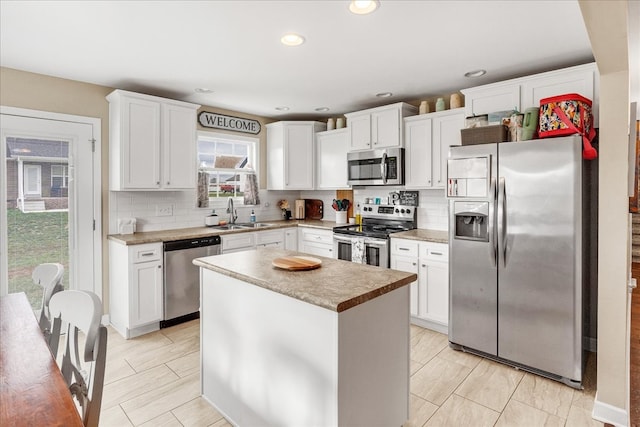 kitchen featuring a kitchen island, white cabinetry, and appliances with stainless steel finishes