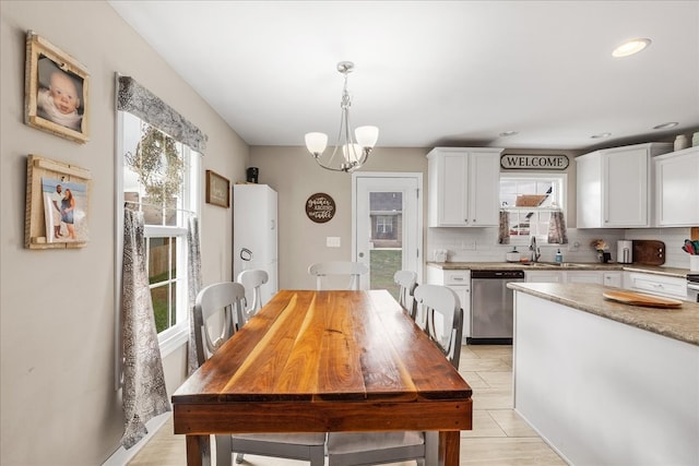 dining area featuring light tile patterned floors, sink, and a notable chandelier