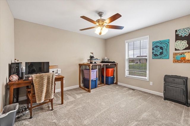 carpeted office space with ceiling fan