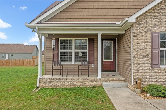 property entrance with covered porch and a lawn