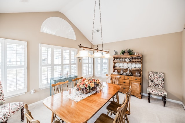 carpeted dining room featuring plenty of natural light and lofted ceiling