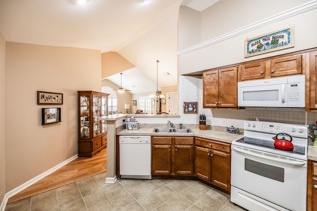 kitchen featuring ceiling fan with notable chandelier, kitchen peninsula, sink, light wood-type flooring, and white appliances