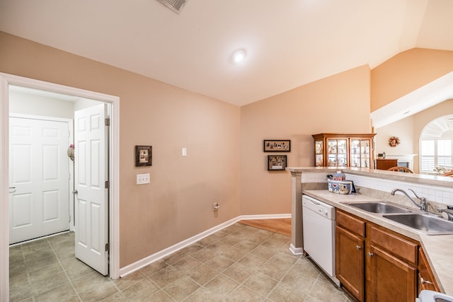 kitchen with light tile patterned floors, lofted ceiling, sink, and dishwasher