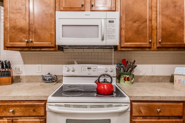 kitchen with tasteful backsplash and white appliances