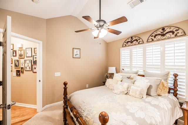 bedroom with ceiling fan, lofted ceiling, and wood-type flooring