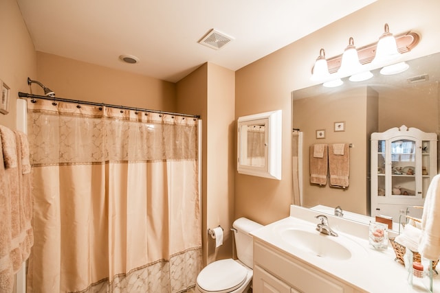 bathroom with a shower with shower curtain, vanity, and toilet