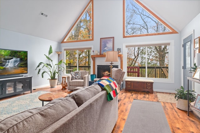 living room with high vaulted ceiling and light wood-type flooring