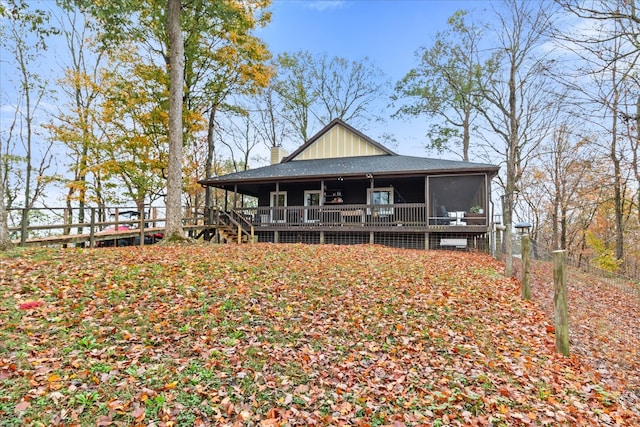 back of property with a wooden deck and a sunroom