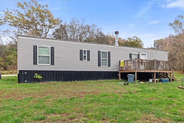 back of property featuring a wooden deck and a yard