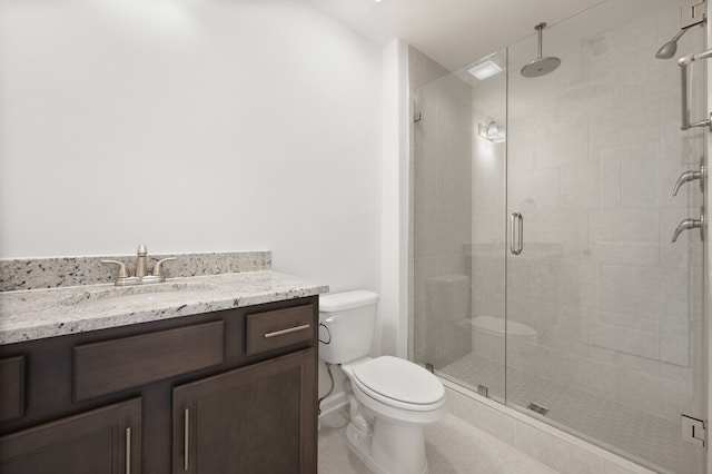 bathroom featuring a shower with door, vanity, and toilet