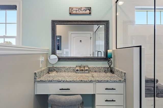 bathroom with vanity, a healthy amount of sunlight, and an enclosed shower