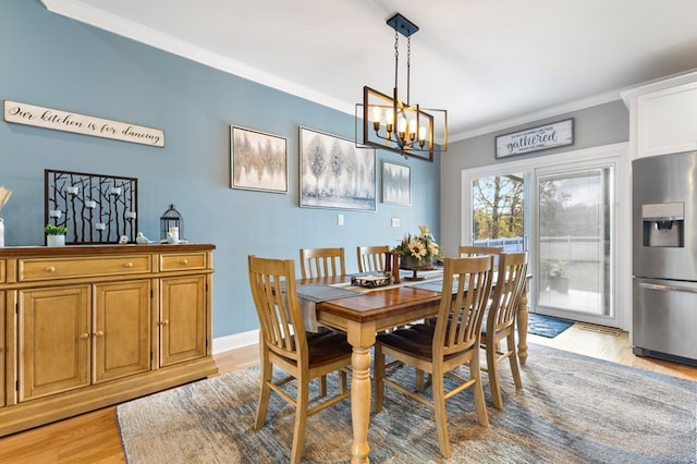 dining room featuring ornamental molding, light hardwood / wood-style flooring, and an inviting chandelier