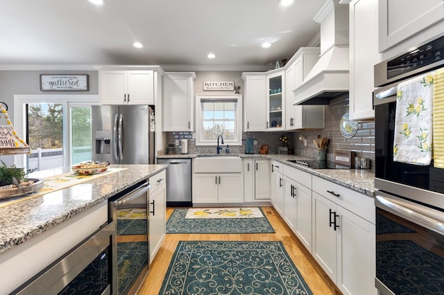 kitchen with stainless steel appliances, plenty of natural light, wine cooler, and sink