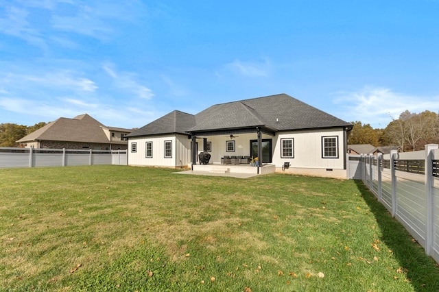 rear view of property featuring ceiling fan, a lawn, and a patio