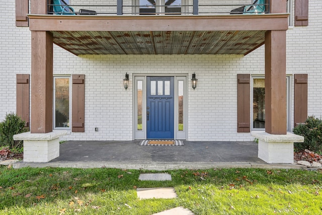 property entrance featuring a porch and a balcony