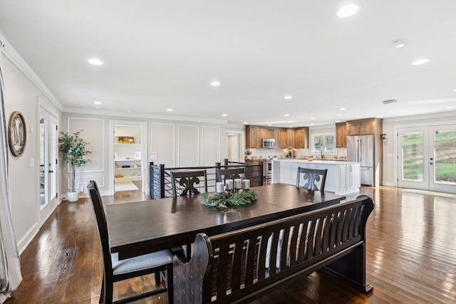 dining area featuring hardwood / wood-style floors, french doors, and crown molding