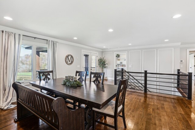 dining space featuring dark hardwood / wood-style floors, built in features, and ornamental molding