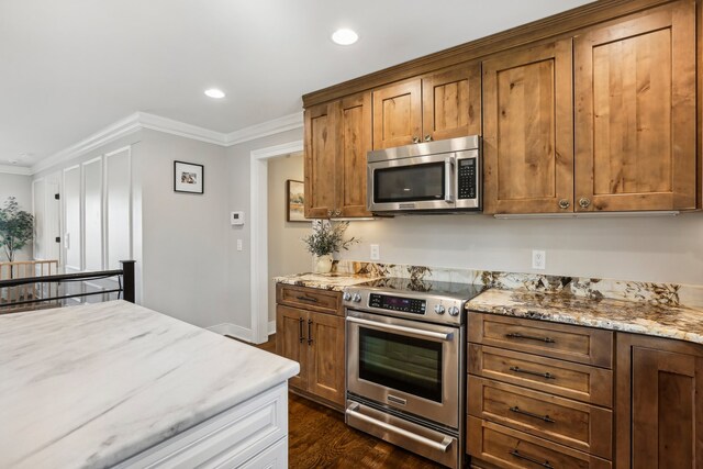 kitchen featuring stainless steel appliances, light stone counters, and crown molding