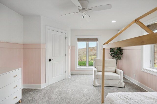 unfurnished bedroom with multiple windows, ceiling fan, and light carpet