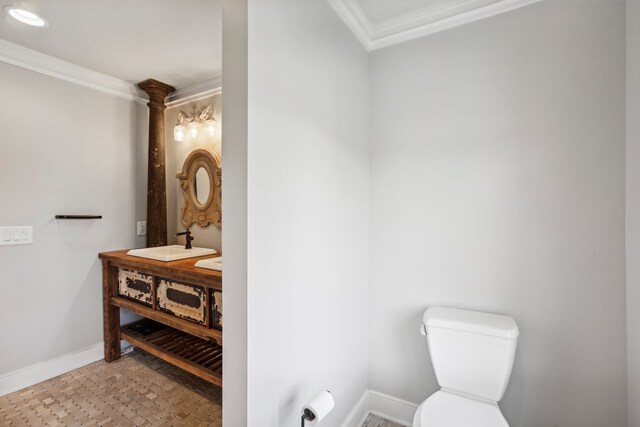 bathroom featuring crown molding and toilet