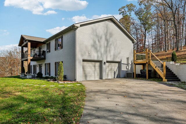 view of home's exterior featuring cooling unit, a garage, a yard, and a balcony