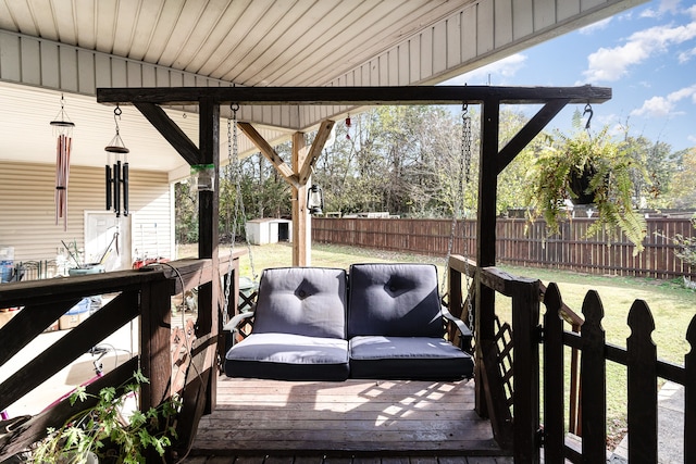 wooden terrace with a yard, a shed, an outdoor structure, and a fenced backyard