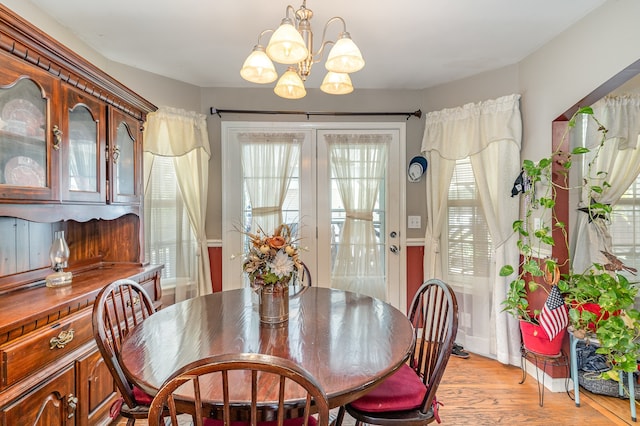 dining room featuring a chandelier, french doors, and light wood finished floors