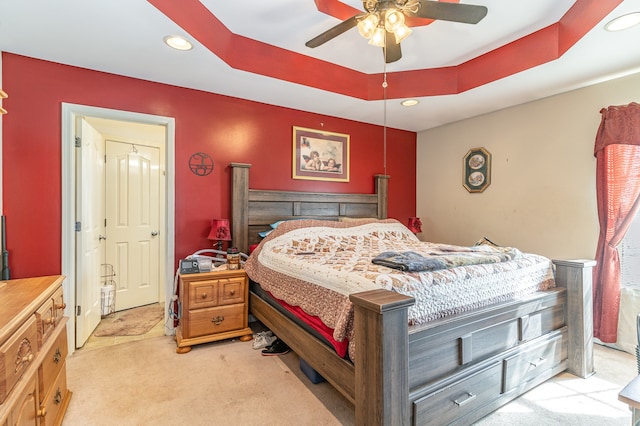 bedroom featuring recessed lighting, a tray ceiling, and light colored carpet