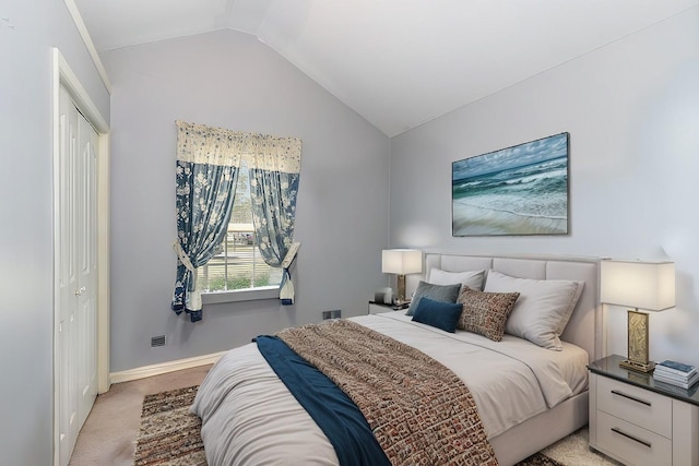 bedroom with light carpet, baseboards, vaulted ceiling, and a closet